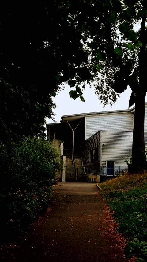 Vertical Video. Path leading to a modern building with metal exterior. Video stock 160080466