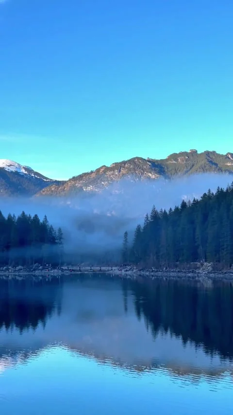 Vertical Video of Peaceful Alpine Lake with Foggy Mountains Stock Footage 337713764
