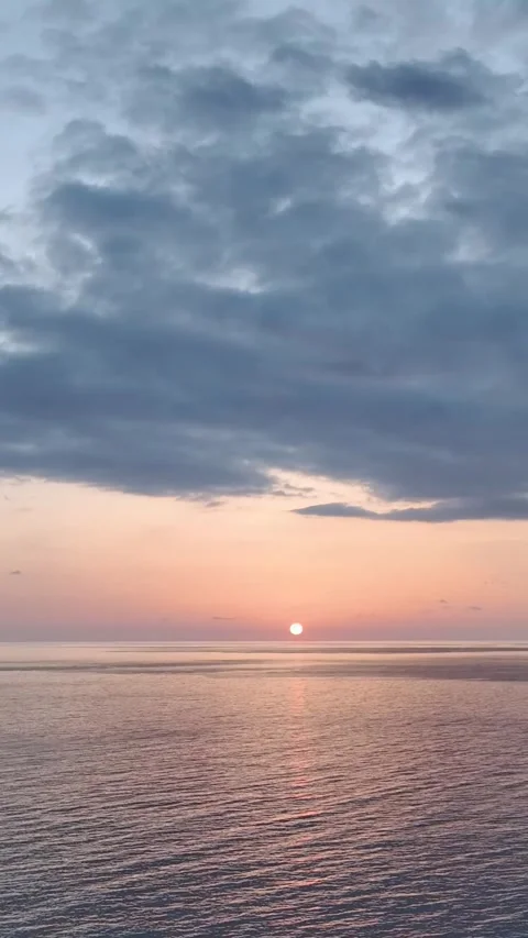 Vertical Video: Peaceful cloudy sunset above the Mediterranean Sea, creating a Stock Footage 297656823