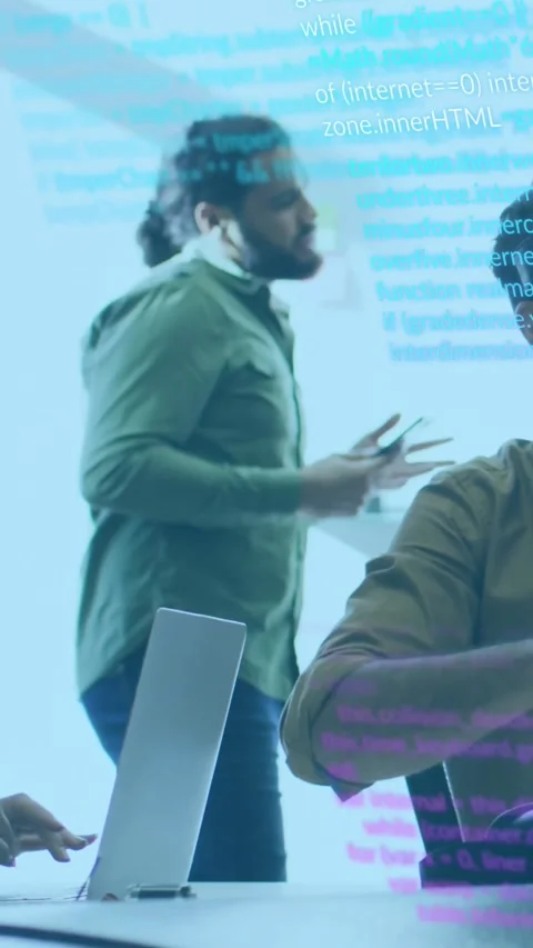 Vertical video: Peer typing laptop, dev with bun walking to table with phone Stock Footage 331128542