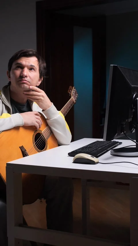 Vertical video Pensive musician composing music with computer and guitar Stock-Footage 308968145