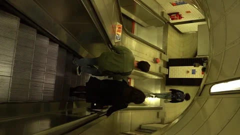 Vertical video of people going down on an escalator to London underground Видео 257327171
