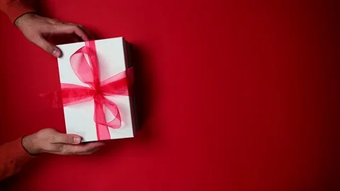 Vertical video of person with gift box. Top view of hands rotating Christmas Stock Footage 202410812