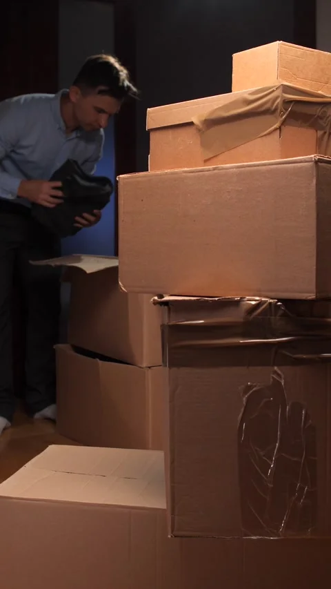 Vertical video Person packing small items into large moving box Stock Footage 318982499