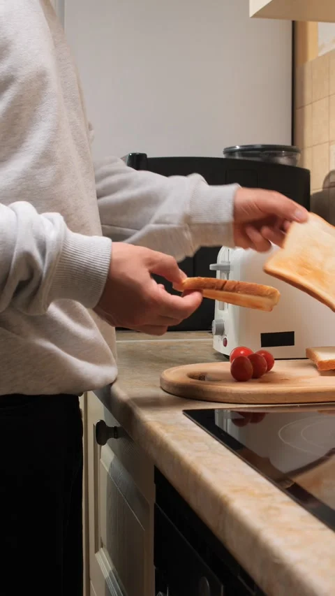 Vertical video person preparing breakfast, pulling a slice of toasted bread Stock Footage 343165727