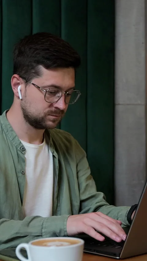 Vertical video. Person using laptop at cafe table for remote work. Stock Footage 345236229