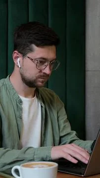 Vertical video. Person using laptop at cafe table for remote work. 스톡 사진