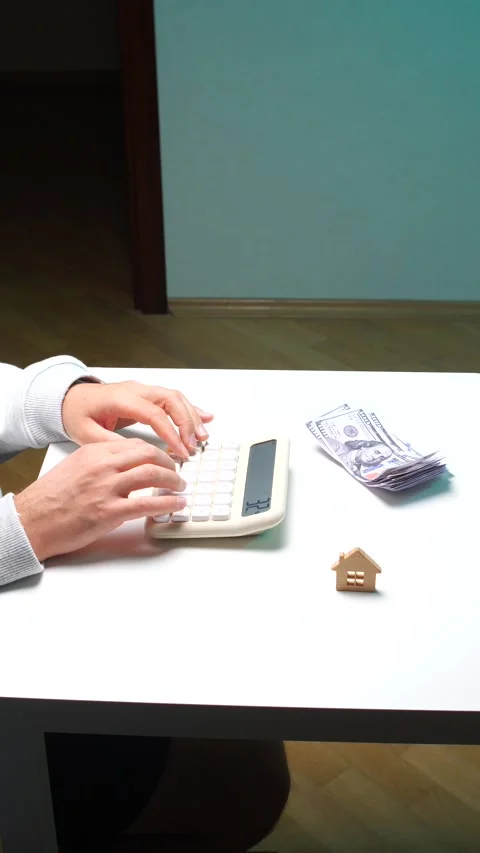 Vertical video person's hands using a calculator on a white desk, with a Stock Footage 345170025