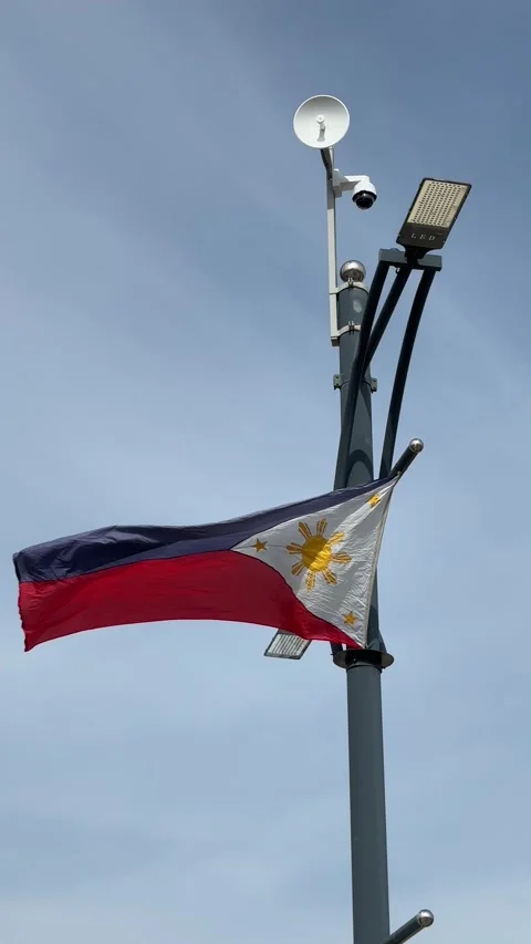 Vertical Video of Philippine Flag Waving Against Blue Sky in Lapu-Lapu City.. 库存影片 336162856