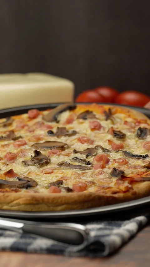 Vertical video, Placing a freshly baked american pizza on the table Stock Footage 282564670