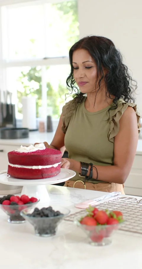 Vertical video: Placing layer, Indian woman frosting red velvet cake with offset Stock Footage 346600209