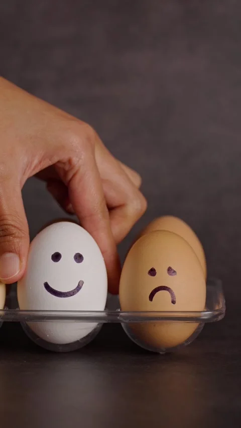 Vertical video, placing a white egg with a happy face in an egg organizer Stock Footage 281372747