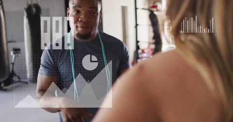 Vertical video: Pointing trainer in dark tee coaching client in gym, with teal Stock Footage 331380337