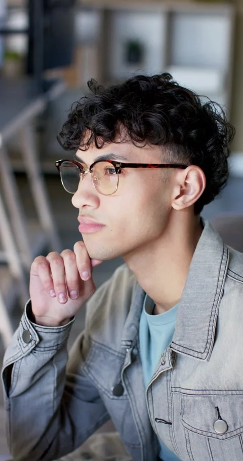 Vertical video: Pondering content, man in his 20s propping chin, typing on Stock Footage 345217617
