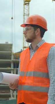 Vertical video. Portrait of an architect or builder in hard hat standing in f Stock Photos