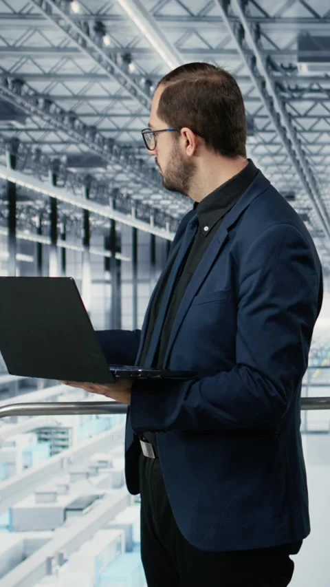 Vertical video Portrait of cheerful man looking at data on laptop, improving Stock Footage 333614026