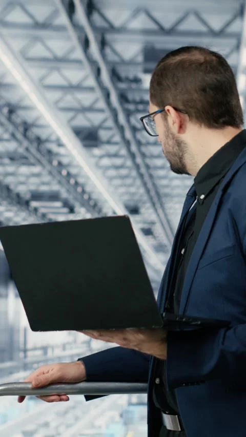 Vertical video Portrait of cheerful man looking at data on laptop, improving Stock Footage 333614376