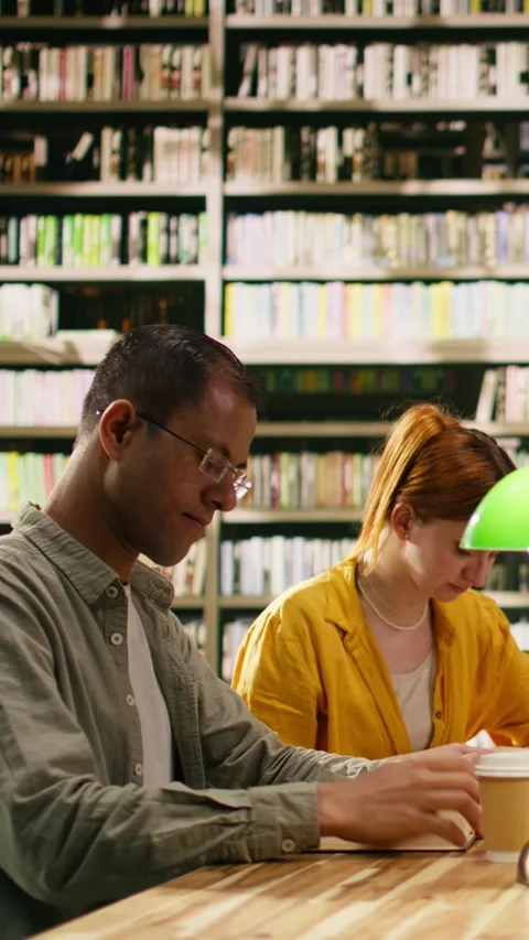 Vertical Video Portrait of classmates in study group sitting at library table Stock Footage 336378757