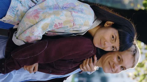 Vertical video. Portrait of a cute smiled lesbian couple looking at the camera Stock Footage 214254115