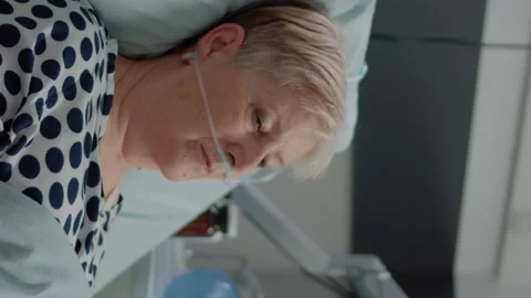 Vertical video: Portrait of elder patient with oxygen tube laying in hospital Stock Footage 163230636