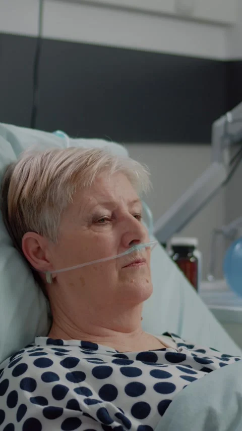 Vertical video: Portrait of elder patient with oxygen tube laying in hospital Video stock 219337416