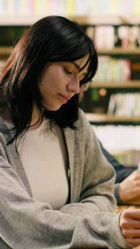 Vertical Video Portrait of focused peer reading open book and studying at Video stock 336380141