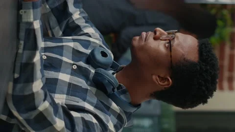 Vertical video Portrait of focused programer writing code fixing glasses and Stock Footage 194149241