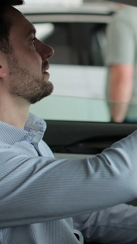 Vertical video Portrait of handsome man touching new car in showroom. Stock Footage 337239688