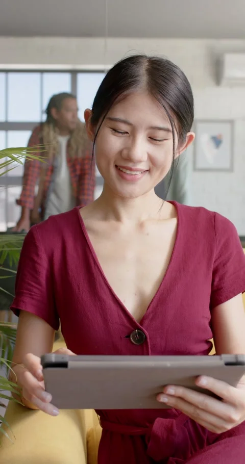 Vertical video of portrait of happy diverse businesswoman using tablet with Stock Footage 345128480
