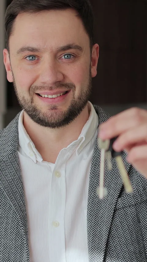 Vertical video Portrait of a happy man real estate agent holding the keys Stock Footage 340082127