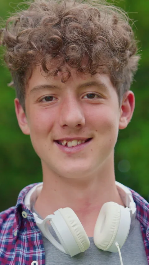 Vertical video. Portrait of happy young curly teenager dancing with headphones Stock Footage 314655055