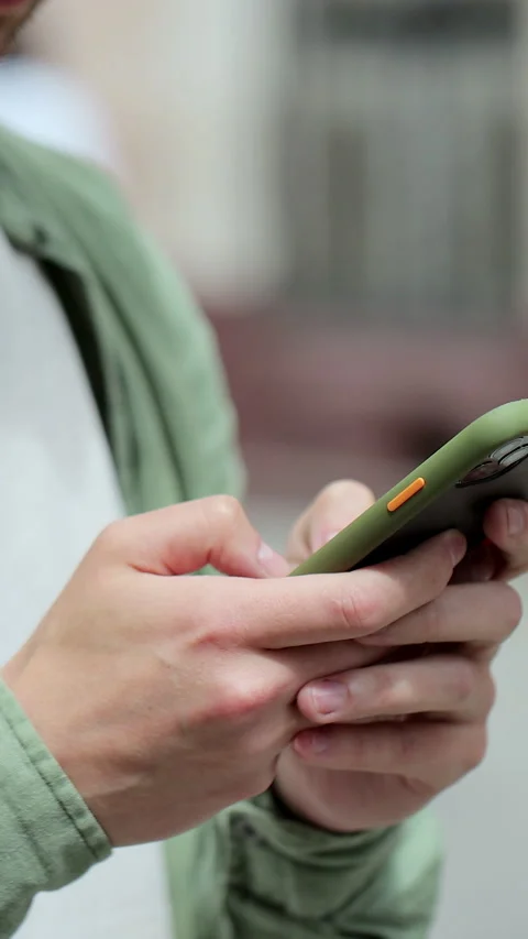 Vertical video. Portrait of a man using a smartphone for messaging Stock Footage 345241348