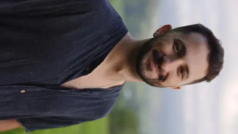 Vertical Video Portrait of the Multiracial Guy Standing, Enjoying his Life While Stock Footage 255569720