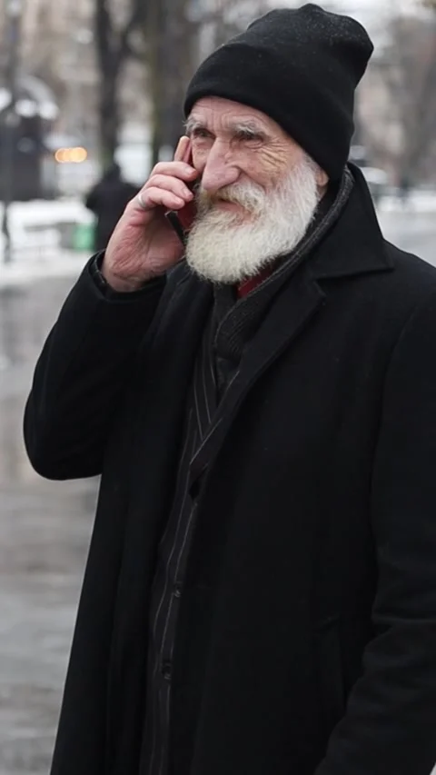Vertical video portrait of an old man talking on the phone while standing Stock Footage 267046748