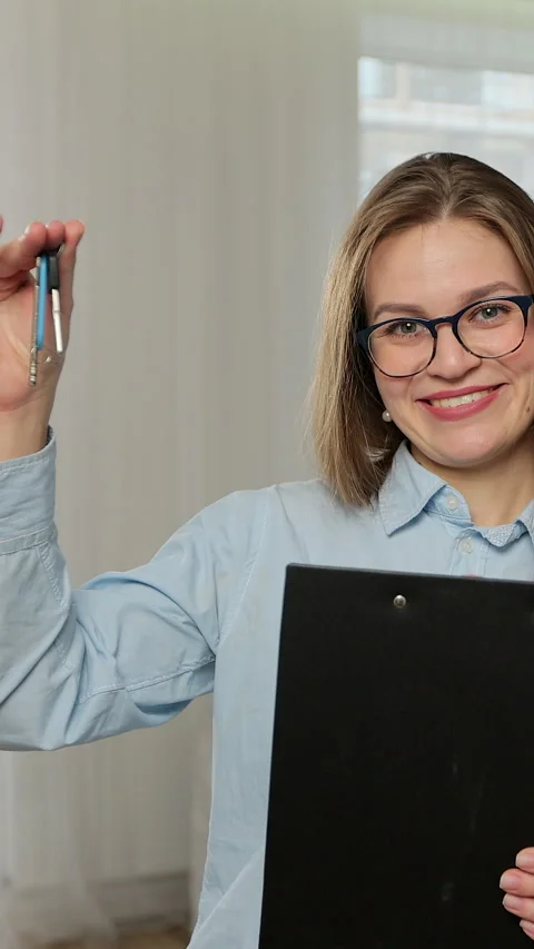Vertical video. Portrait of real estate agent holding house key. Stock Footage 346200880