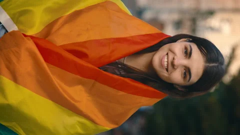 Vertical video. Portrait of smiled young woman covering herself in lgbt flag Stock Footage 220052962