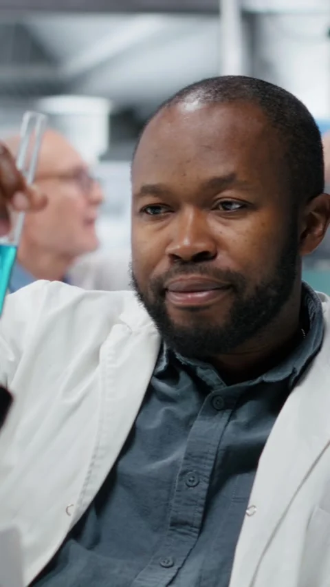 Vertical video Portrait of smiling lab scientist investigating liquid polymer in Stock Footage 325680884