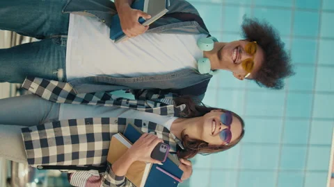 Vertical Video. Portrait of Two Students with Books on Background of University. Video stock 241277271