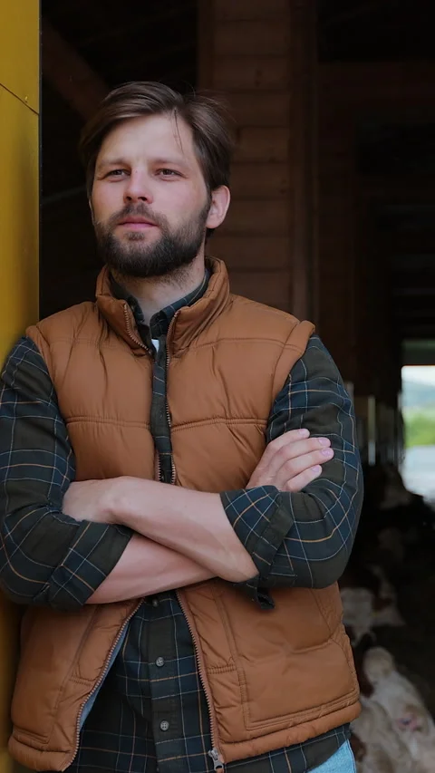 Vertical video. Portrait of a young farmer on a dairy farm. Stock Footage 344629829
