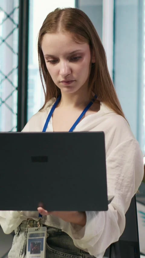 Vertical video Portrait of young smiling female programmer in office automating Stock Footage 312768297