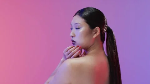 Vertical video: Posing model turning profile to gaze on camera cue in studio, Stock Footage 334112777