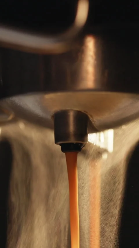 Vertical Video of Pouring coffee stream from professional machine in cup. Making Stock Footage 305233460