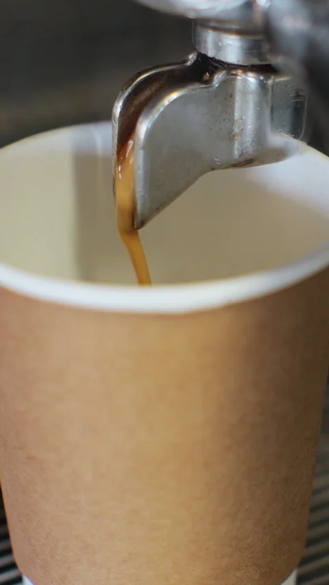 Vertical video. Pouring coffee stream from machine in cup. 動画素材 344107539