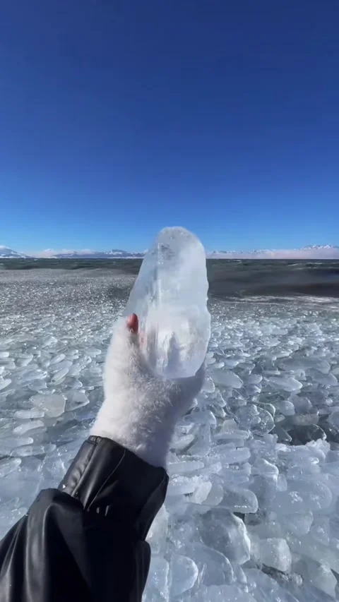 Vertical video POV of hand in white glove holding up a large crystal clear i Vídeos de archivo 327691809