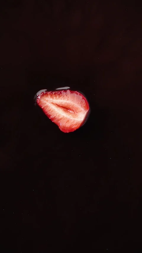VERTICAL VIDEO POV slice of ripe strawberry falling into chocolate, slow motion Stock Footage 280239860