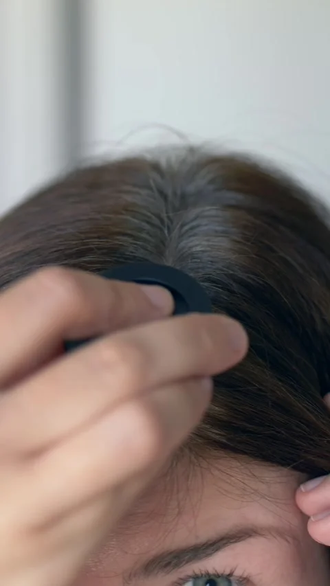 Vertical video. Powder sponge gently blends over gray hair roots, masking gray Video stock 322616985