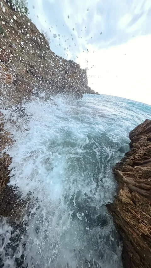 Vertical video. A powerful slow-motion shot of a wave crashing forcefully into Stock Footage 293740865
