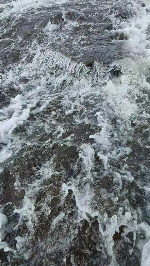 Vertical video of powerful water current cascading over river rocks Stock Footage 331851349