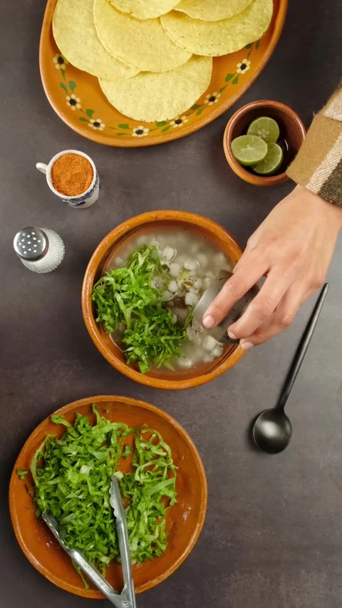 Vertical video Pozole adding oregano mexican gastronomy Stock Footage 280360959
