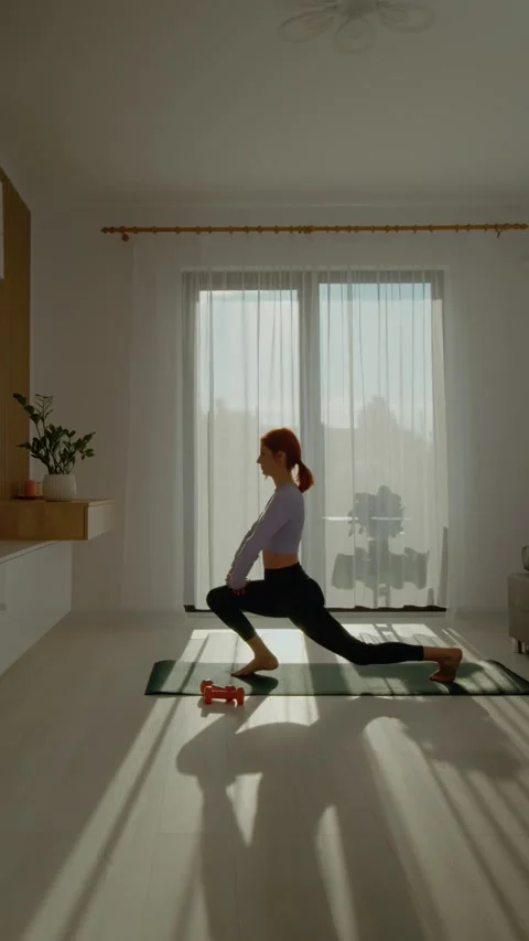 Vertical video Practicing pilates and stretching in a sunny living room for Stock Footage 309442571